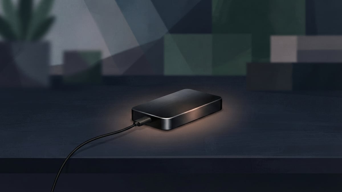 Small hardware wallet on a dark table with a loose wire.